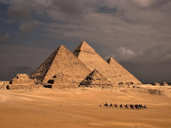 Carovana di cammelli davanti alle tre Piramidi di Giza
