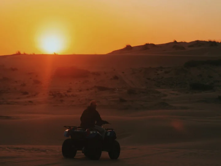 Quad singolo tra le dune al tramonto