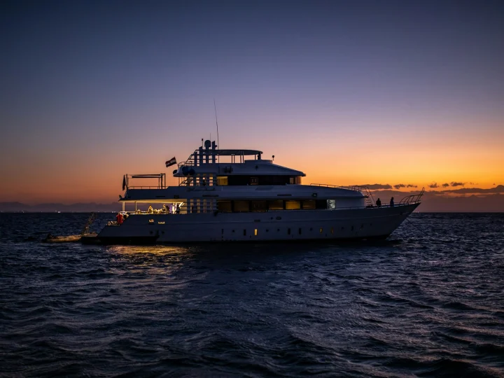 Yacht illuminato in mare al tramonto